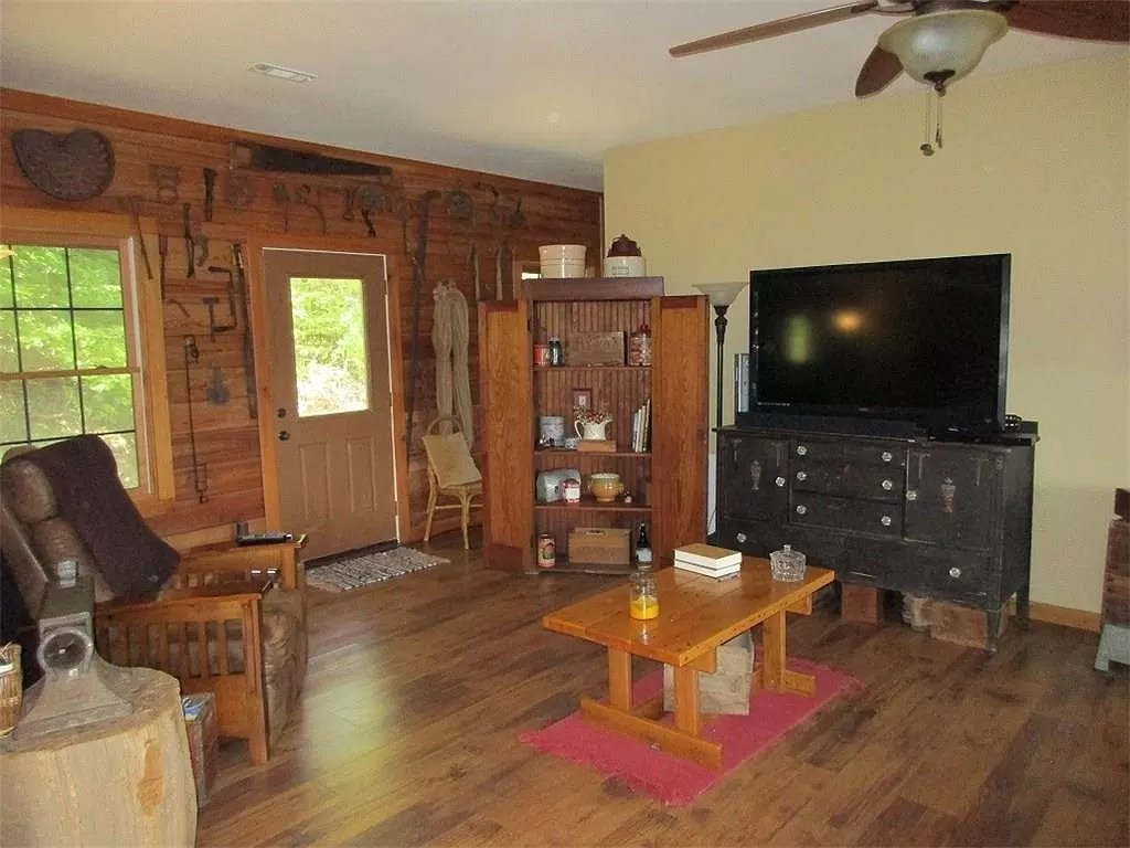 The living room of the log house with wood walls and a wood floor