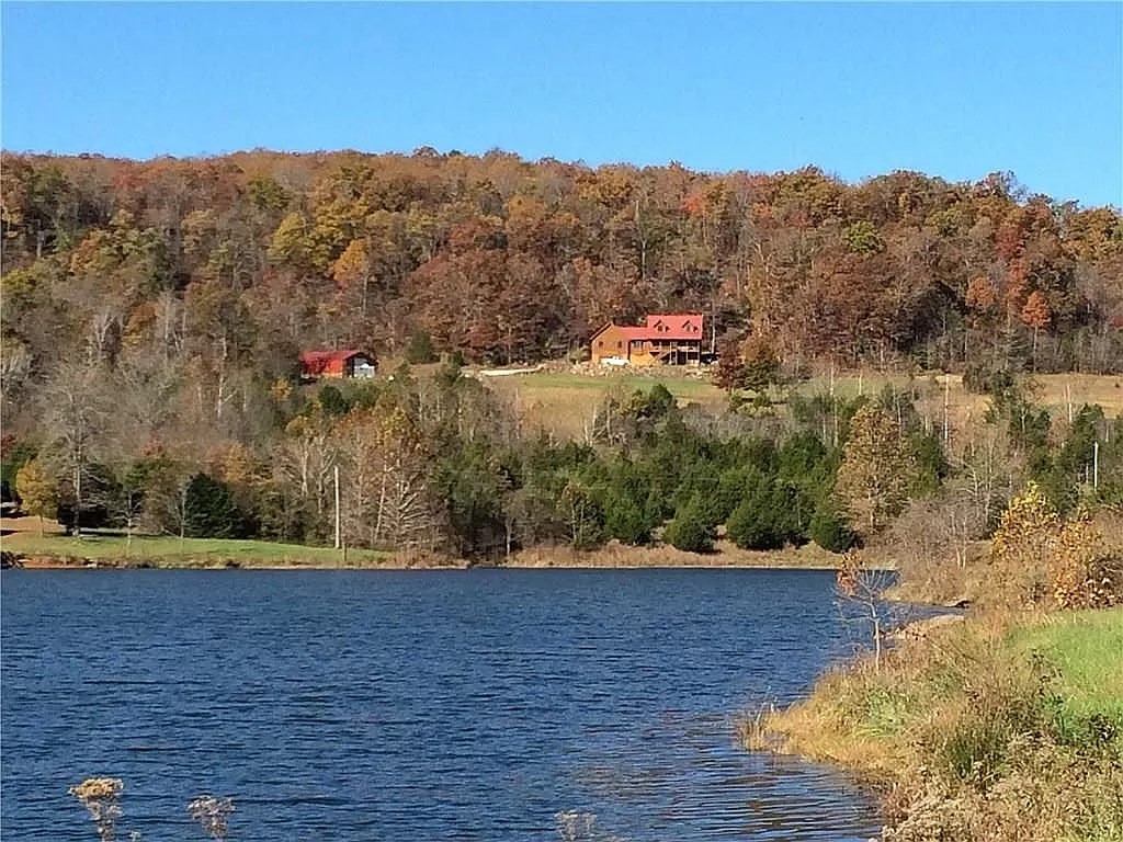 The lake in autumn with wooded hills and red-roofed homes on the far shore