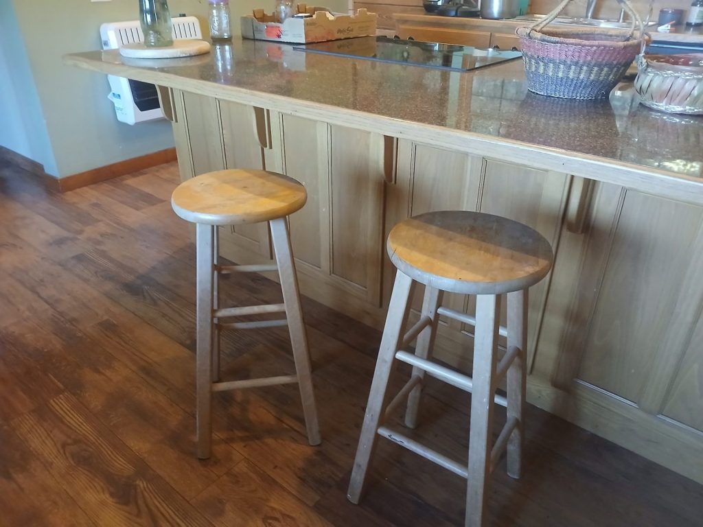 Two round wooden stools pulled up to the kitchen bar